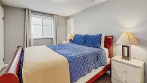 A bedroom with a bed, bedside lamps, a nightstand, and a window with curtains. - Dog Friendly Room with Kitchen Located Near the Beach and Downtown (Rockaway Beach)