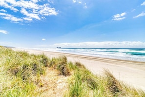 A beach with sand dunes and ocean waves. - Dog Friendly Room with Kitchen Located Near the Beach and Downtown (Rockaway Beach)