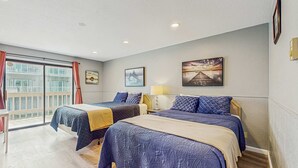 Une chambre d’hôtel avec deux lits, un balcon et des œuvres d’art aux murs.