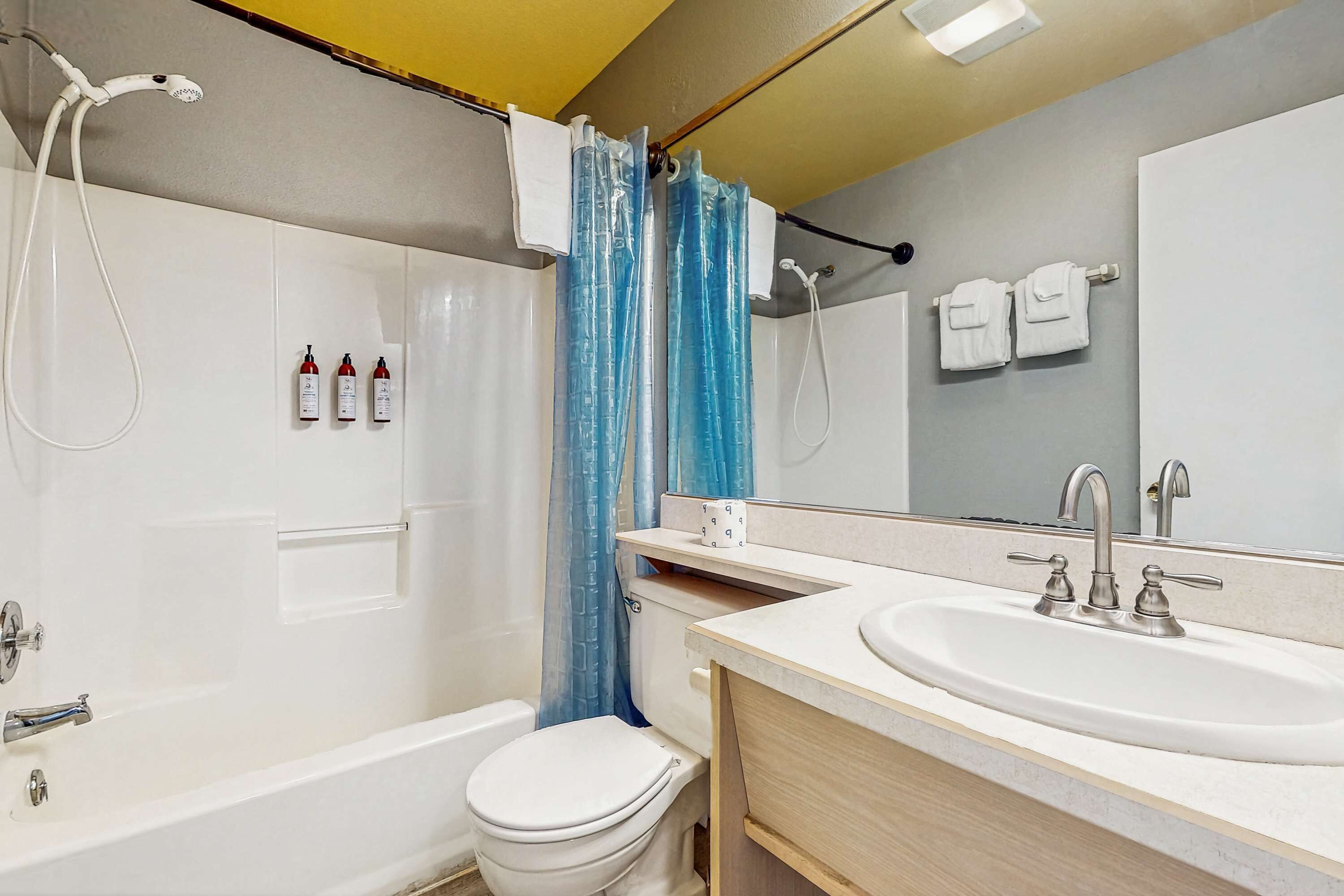 A modern bathroom with a bathtub, toilet, and sink.