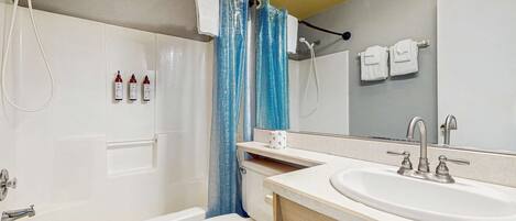 A modern bathroom with a bathtub, toilet, and sink.