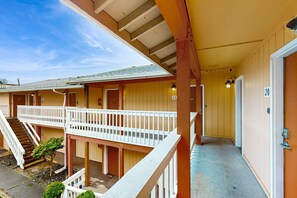 A hotel with a covered outdoor area, a staircase, and a series of doors numbered 9 to 20. - Dog Friendly Motel Room Located Near the Beach and Downtown (Rockaway Beach)