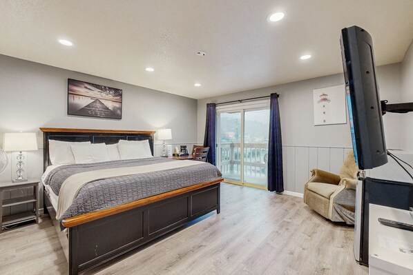 A modern bedroom with a large bed, bedside tables, a desk, and a chair. - Inviting Room Blocks From the Beach and Downtown Dogs Welcome (Rockaway Beach)