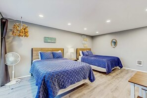 A hotel room with two beds, a fan, a small table, and a wall-mounted mirror. - Ideally Located Room Near Downtown and the Beach Dog Friendly (Rockaway Beach)
