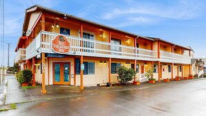 Un motel avec une enseigne indiquant « Sea Treasures Inn » et une autre indiquant « Complet ».