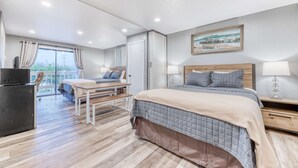 Un dormitorio con cama, mesitas de noche, un escritorio y una silla.