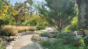 Un jardin avec un chemin de pierres menant à une maison.