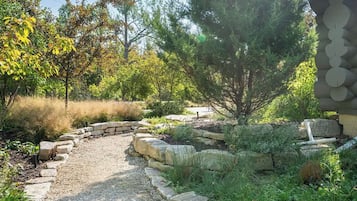 Um jardim com um caminho de pedra que leva a uma casa.