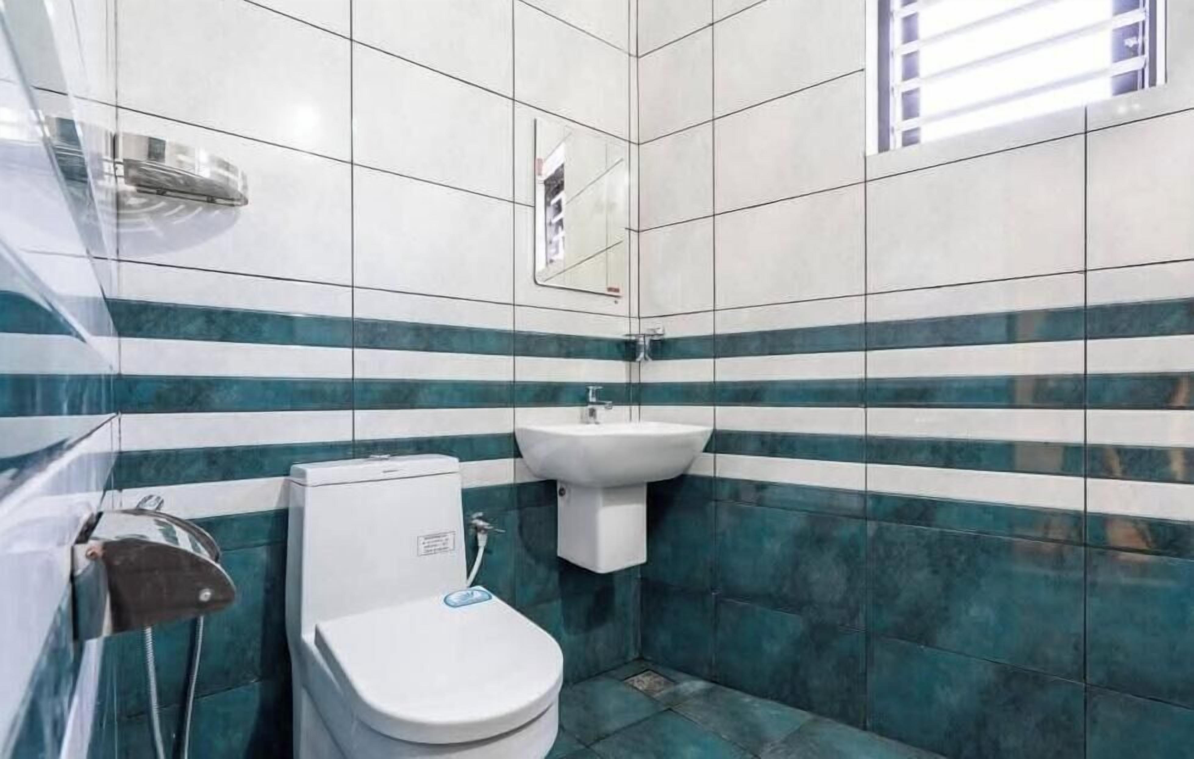 A small bathroom with a toilet, sink, and a mirror.