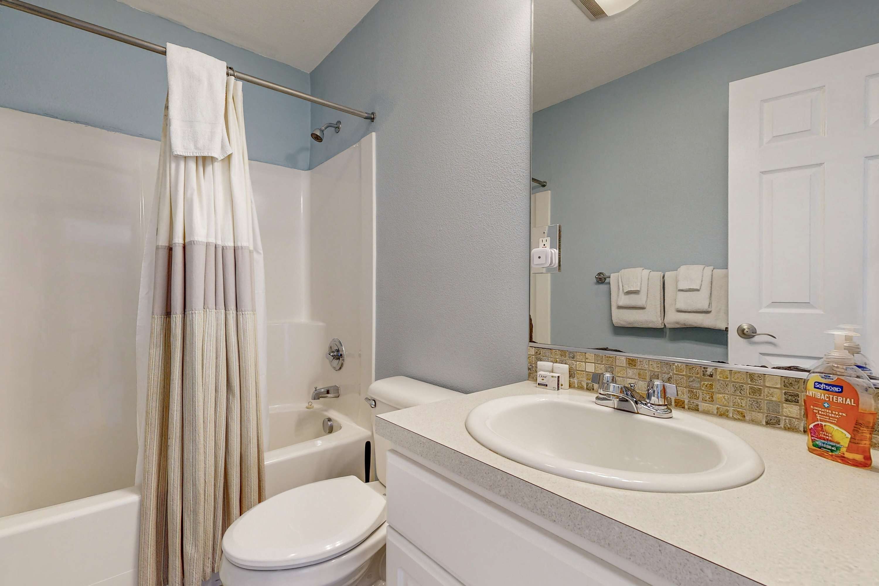 A bathroom with a bathtub, toilet, and sink.