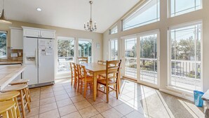 A spacious kitchen with a dining area, large windows, and a view of the outdoors. - Ocean side home steps from sand dog friendly (Rockaway Beach)