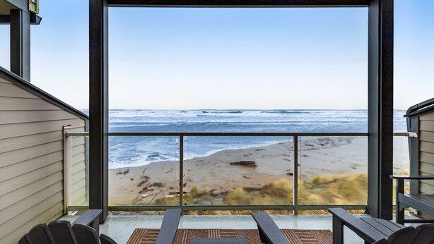 Un balcón con vista a la playa y al océano.