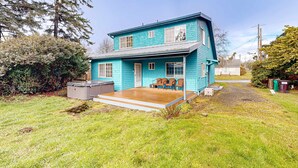 A two-story house with a porch and a small deck. - Cozy family home away from home dog friendly with nearby beach access and hot tub (Rockaway Beach)