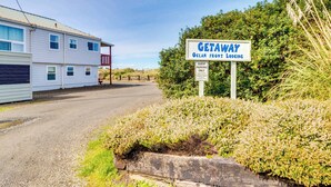 A sign for a getaway named "Ocean from Lodging" with a guest parking sign. - Family Friendly Oceanfront Condo with Free WiiFi Ocean Views and Easy Beach Access (Rockaway Beach)
