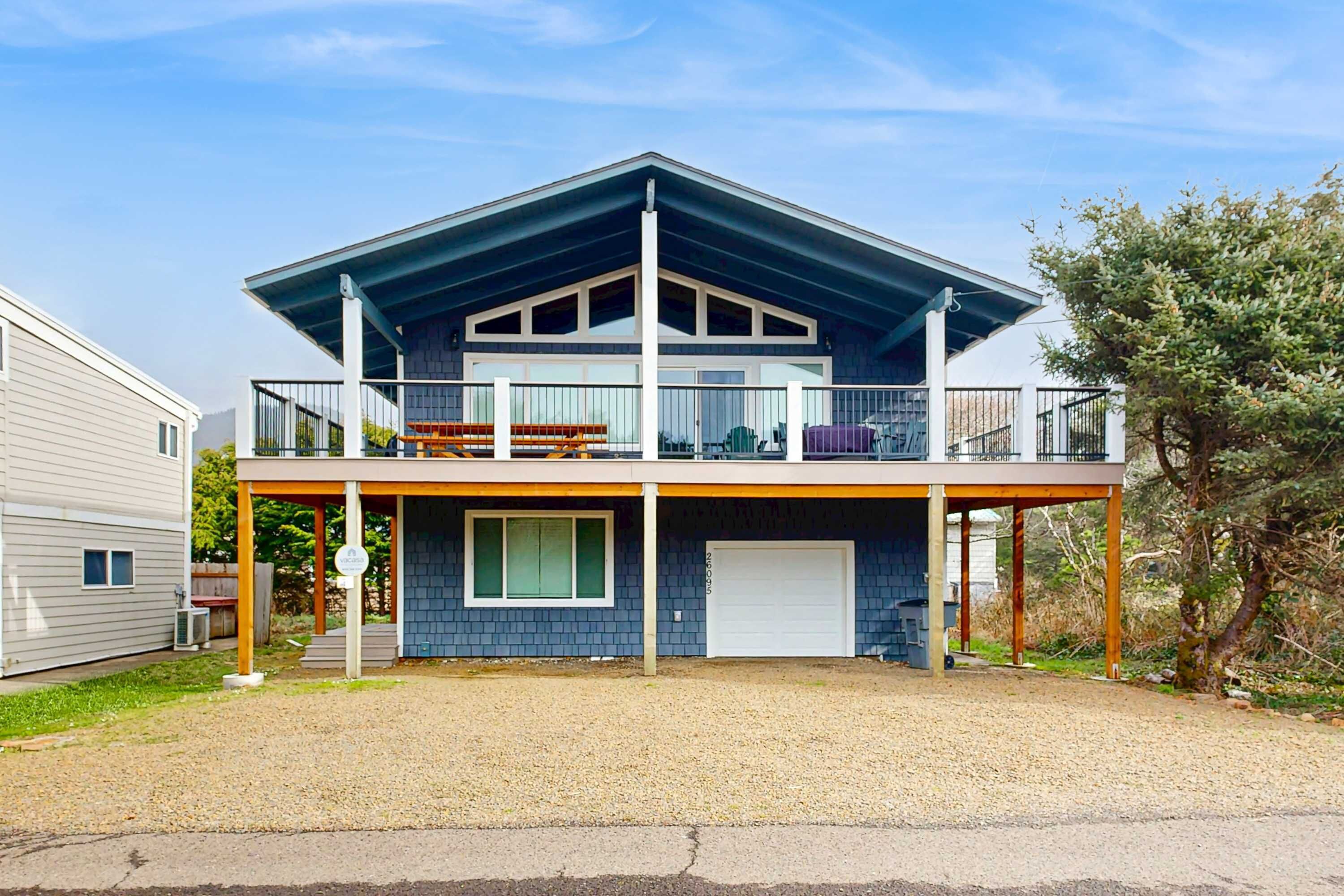 A two-story house with a covered porch, a garage, and a large window.