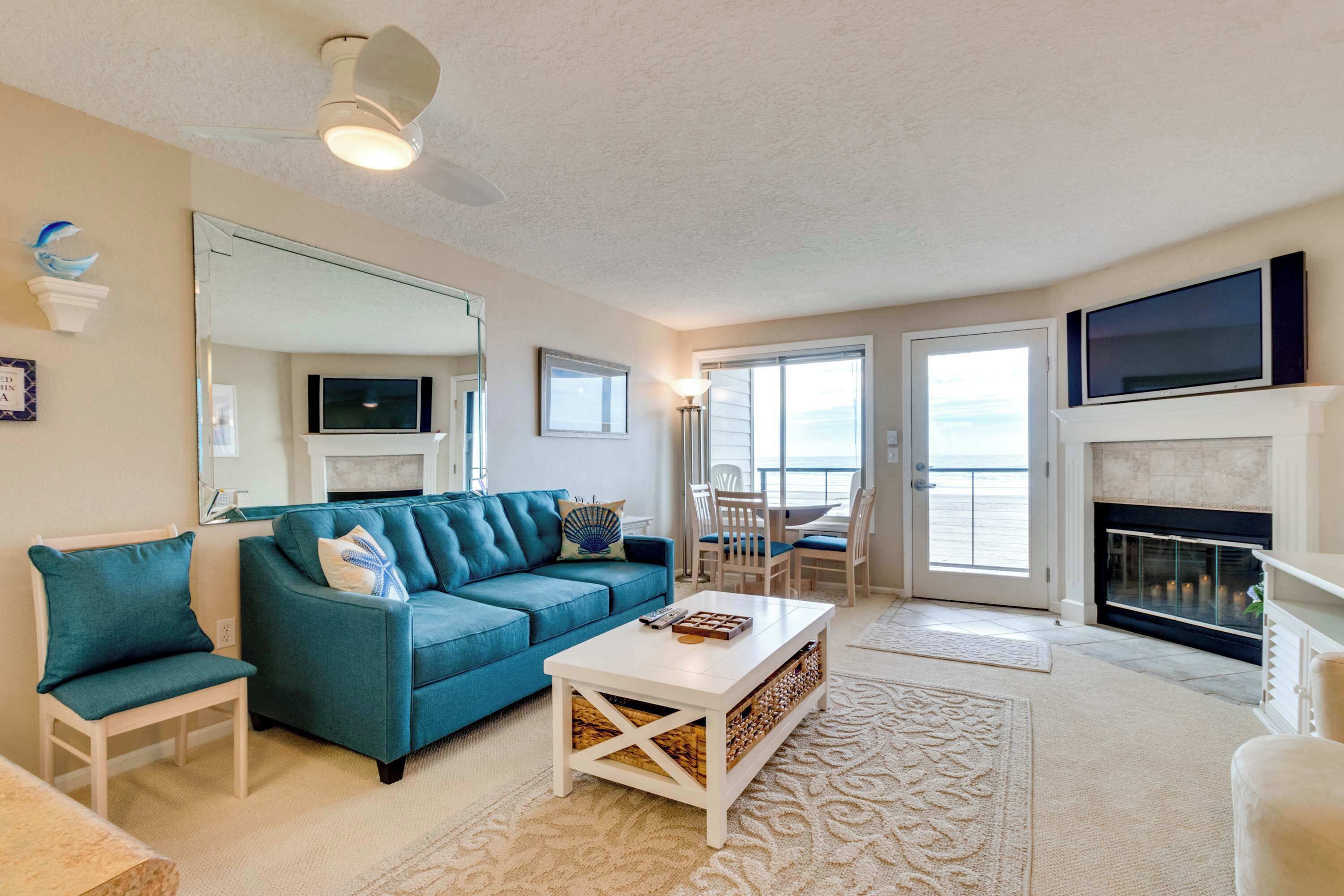 A living room with a blue sofa, a white coffee table, and a fireplace.