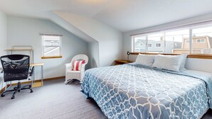A bedroom with a bed, a desk, a chair, and a window. - Ocean view home with prime walkable location near beach and town 2 dogs OK (Rockaway Beach)
