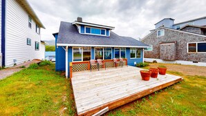 A house with a deck, a covered patio, and a fenced backyard. - Ocean view home with prime walkable location near beach and town 2 dogs OK (Rockaway Beach)