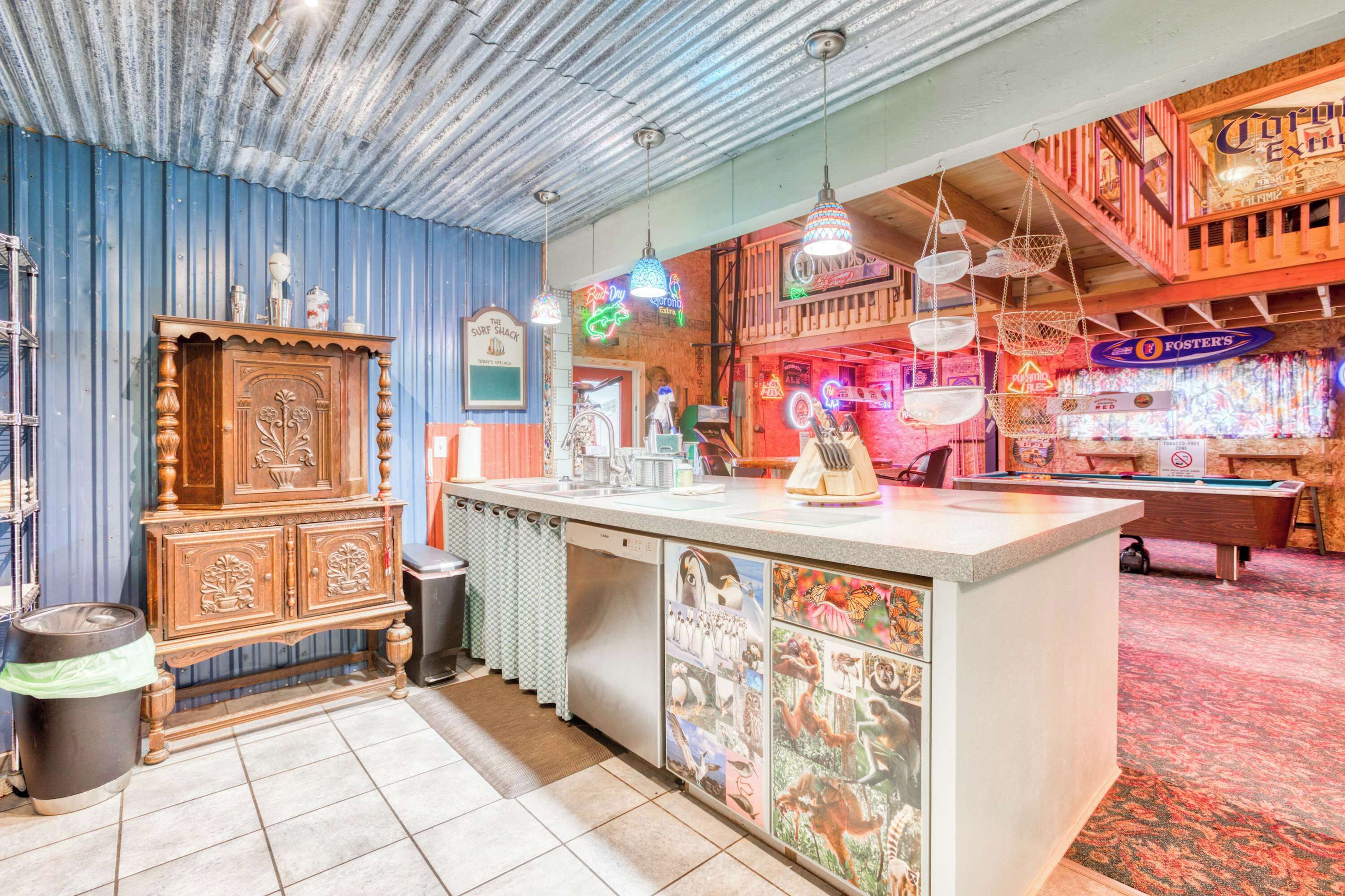 A bar area with a wooden bar counter, neon signs, and a mural of animals.