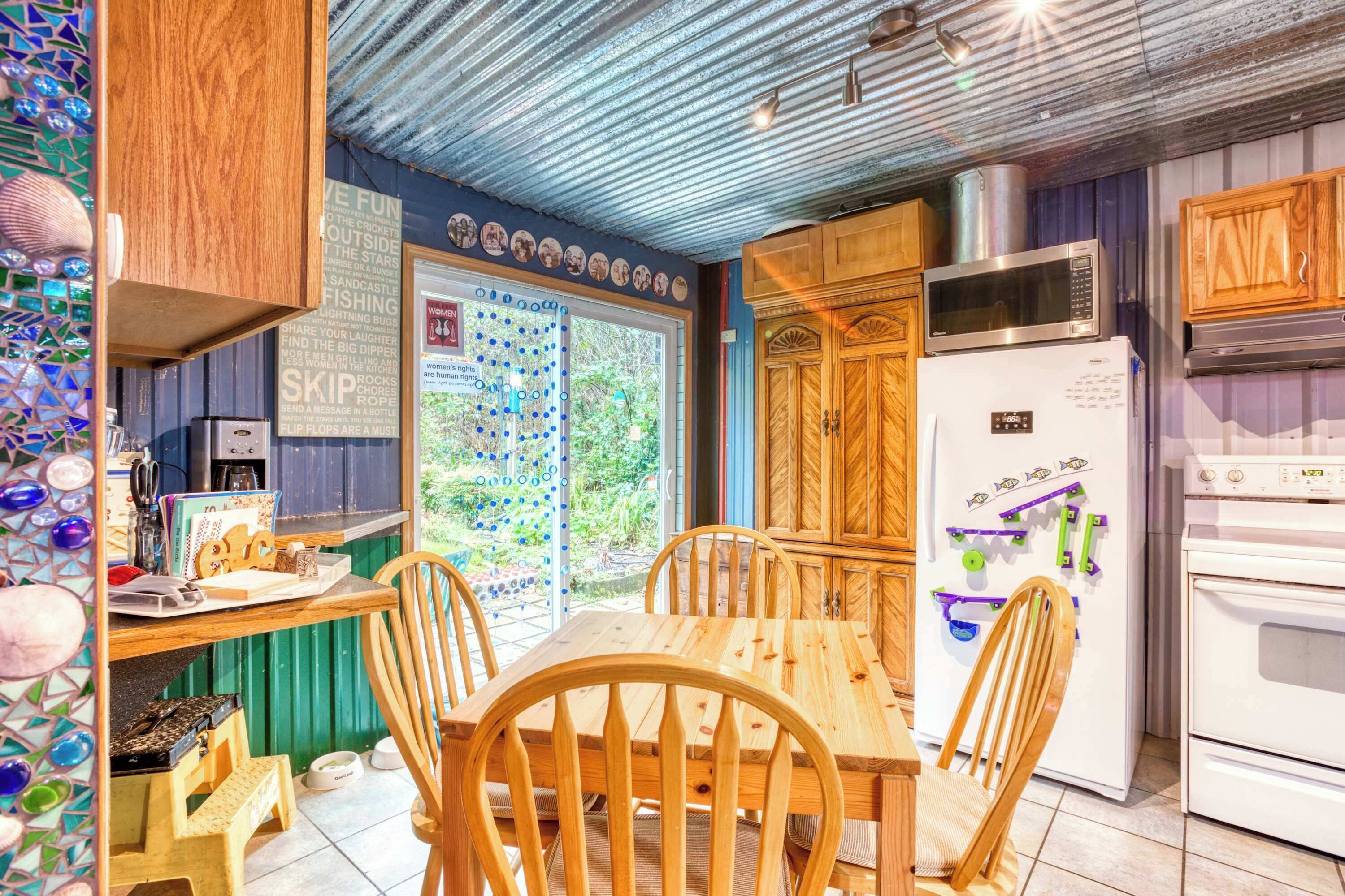 A kitchen with wooden cabinets, a refrigerator, a microwave, and a dining table with chairs.