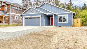A two-story house with a blue garage and a red door.