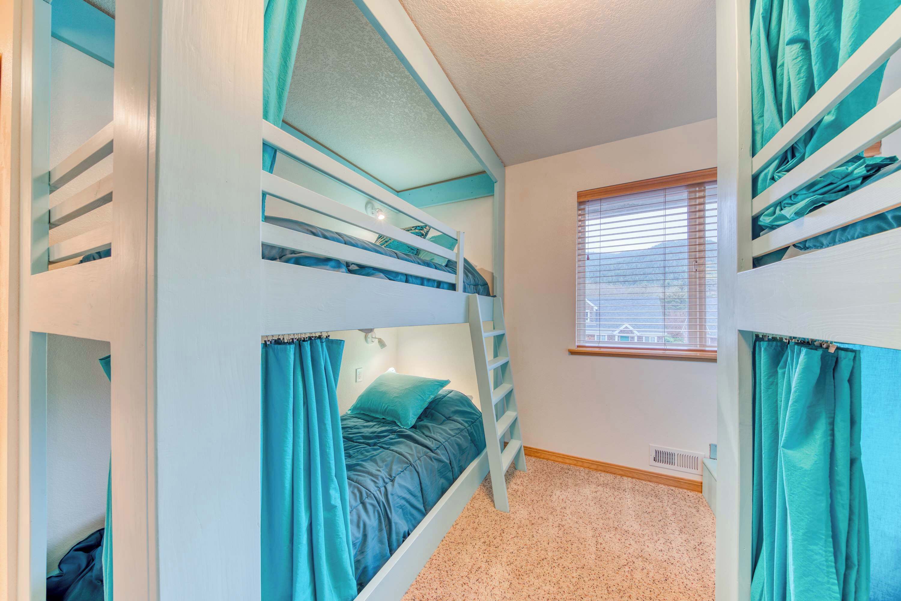 A room with bunk beds, a window with blinds, and a carpeted floor.