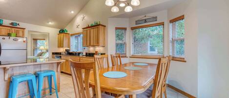A spacious kitchen with wooden cabinets, a central island, and blue bar stools.