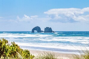 A beach with two rock formations in the ocean. - Relax and Enjoy Expansive Ocean Views from Your Own Private Retreat (Rockaway Beach)
