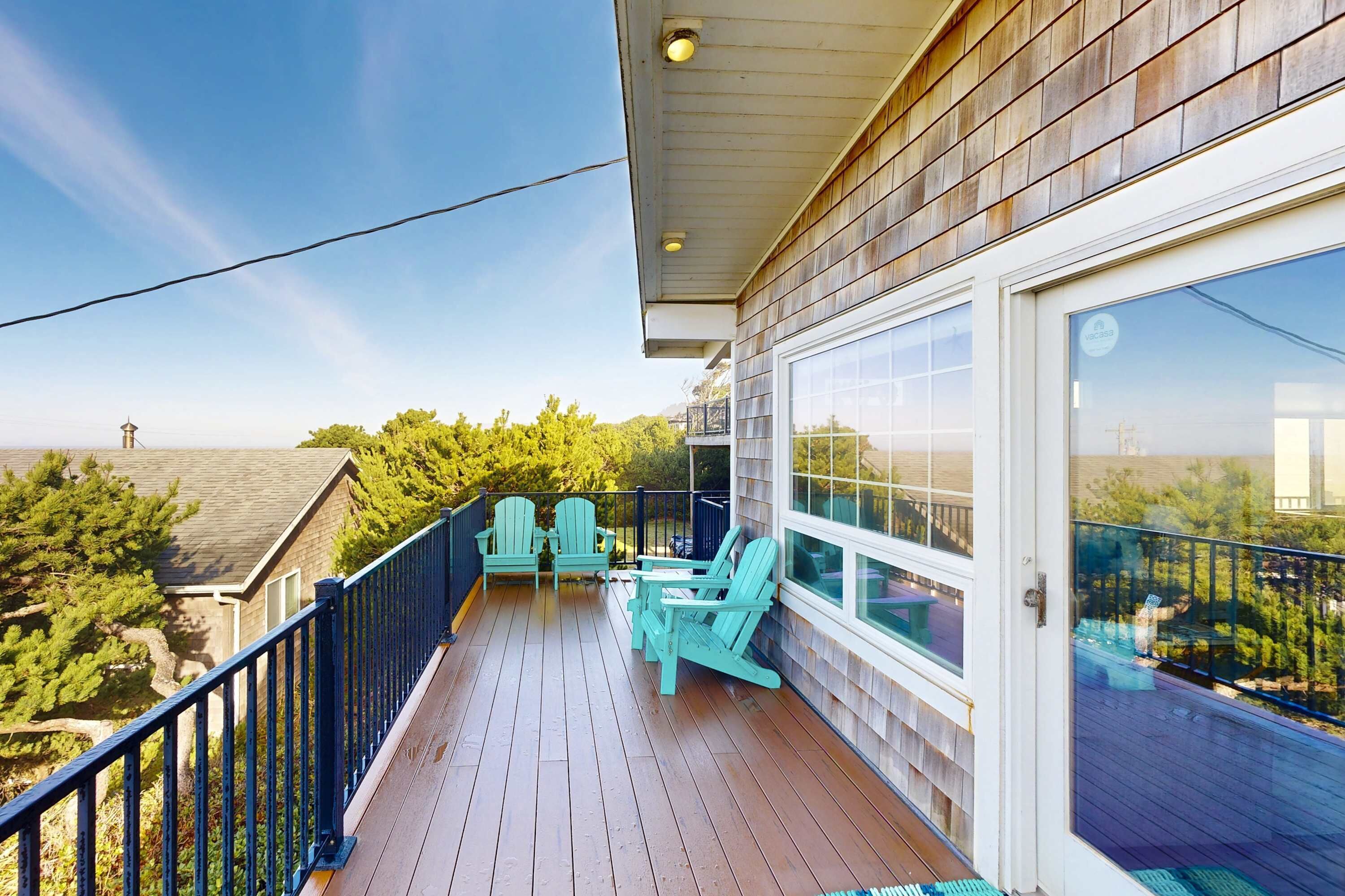 A wooden deck with outdoor seating and a glass door leading to a balcony.