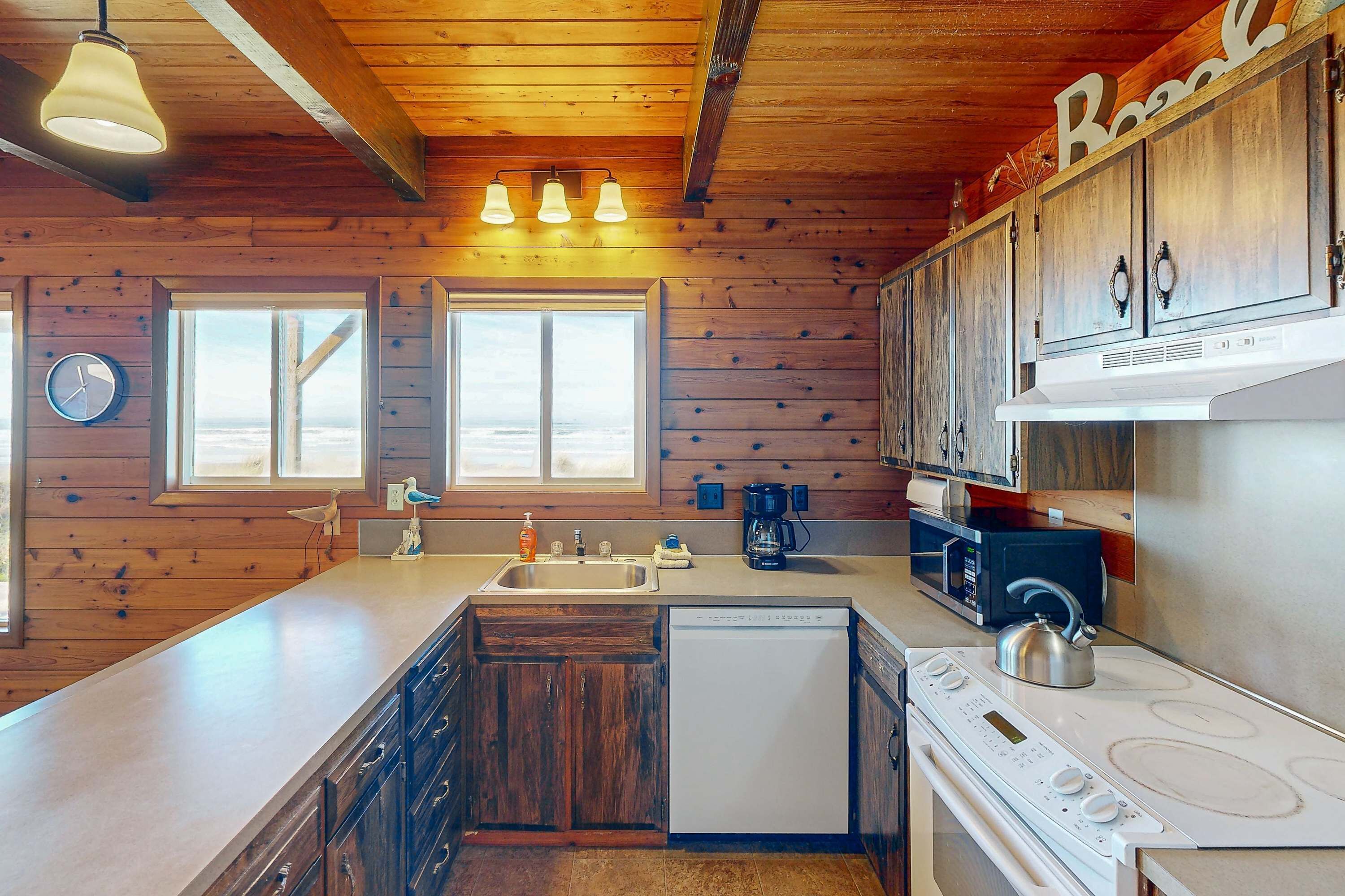 Una cocina con paredes de madera, una estufa blanca, un fregadero y un lavavajillas.