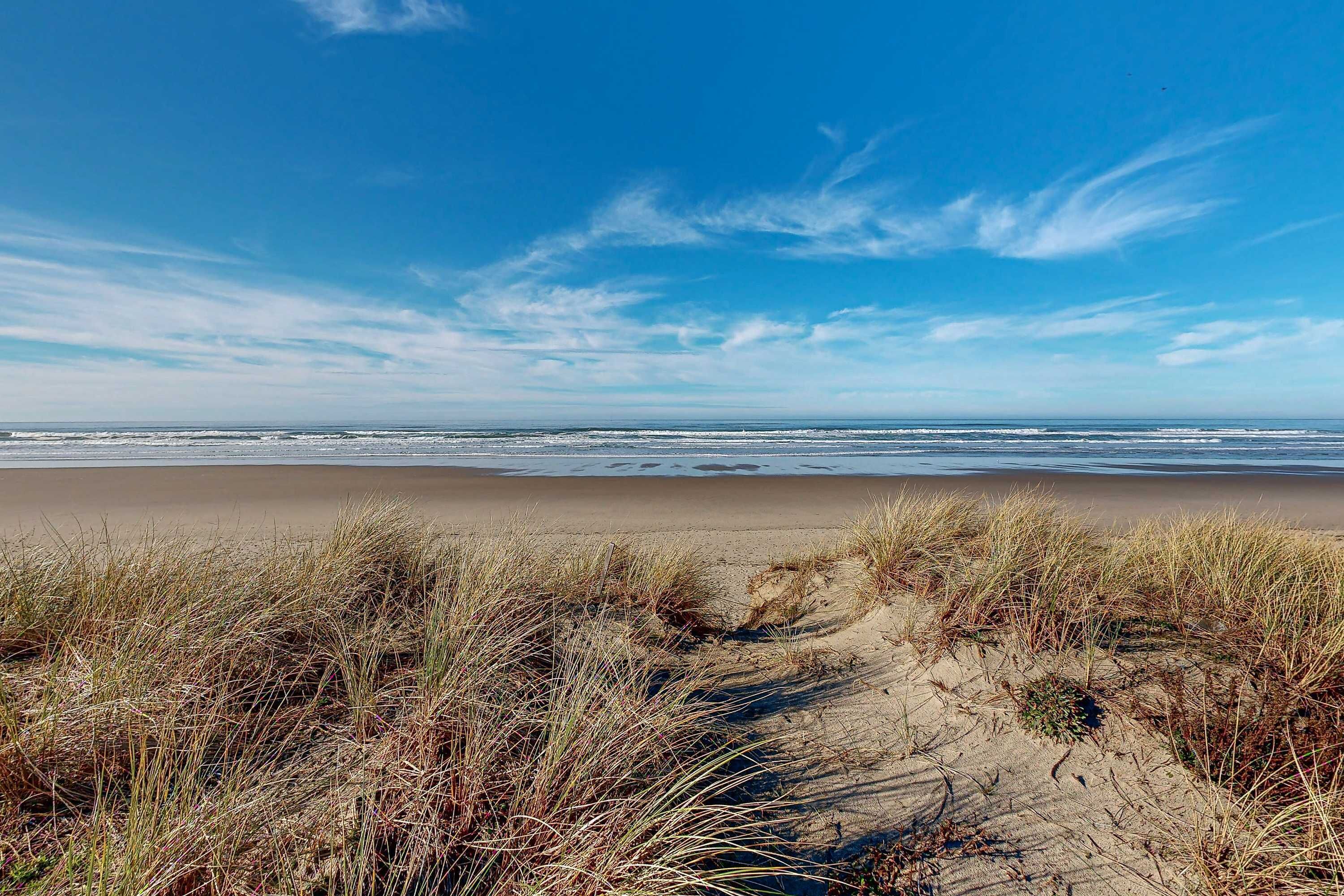 Uma praia com dunas de areia e ondas do mar.