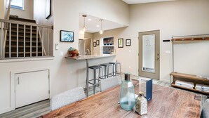 A modern kitchen with a central island, bar stools, and pendant lighting. - New Family Friendly Home with a Furnished Patio and Tranquil Yard (Rockaway Beach)