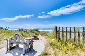 A bench near a wooden fence overlooking a beach with the ocean in the background. - Dog friendly beach house with two full kitchens a private hot tub and Ping Pong (Rockaway Beach)