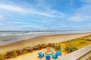 A beach with a fire pit and blue chairs, overlooking the ocean. - Prime Direct Beachfront Retreat with private deck with views | Dogs Welcome (Rockaway Beach)