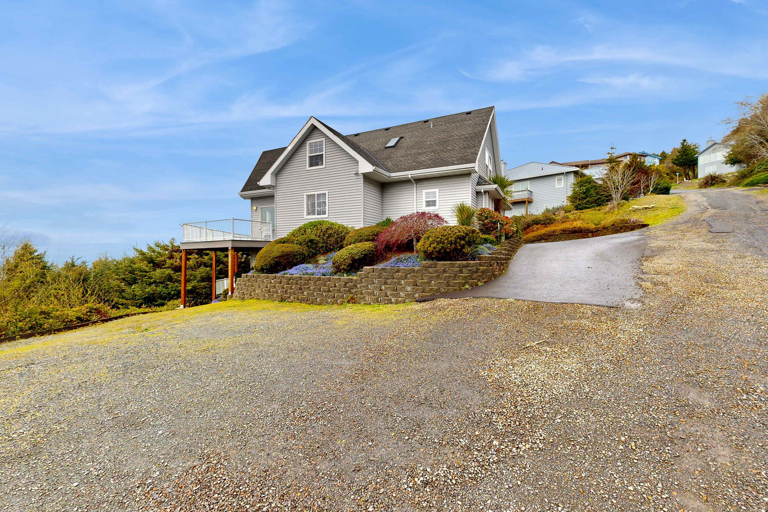 A two-story house with a gravel driveway and a small porch.