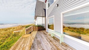A wooden deck with a bench, overlooking a beach with a view of the ocean and dunes. - Oceanfront Home with Great Ocean View Deck Fireplace Beach Access 2 Dogs OK (Rockaway Beach)