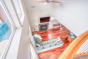 A spacious living area with a fireplace, a sofa, and a dining table.