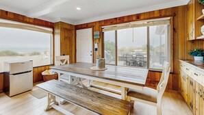 A kitchen with wooden walls, a large window, and a view of the beach. - Oceanfront home with great views high speed WiFi and direct beach access (Rockaway Beach)