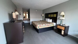 A hotel room with a bed, bedside tables, a desk, and a wardrobe.