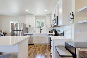 Fridge, microwave, oven, stovetop - Modern Beach Cottage with a covered patio fire pit grill and easy beach access (Rockaway Beach)