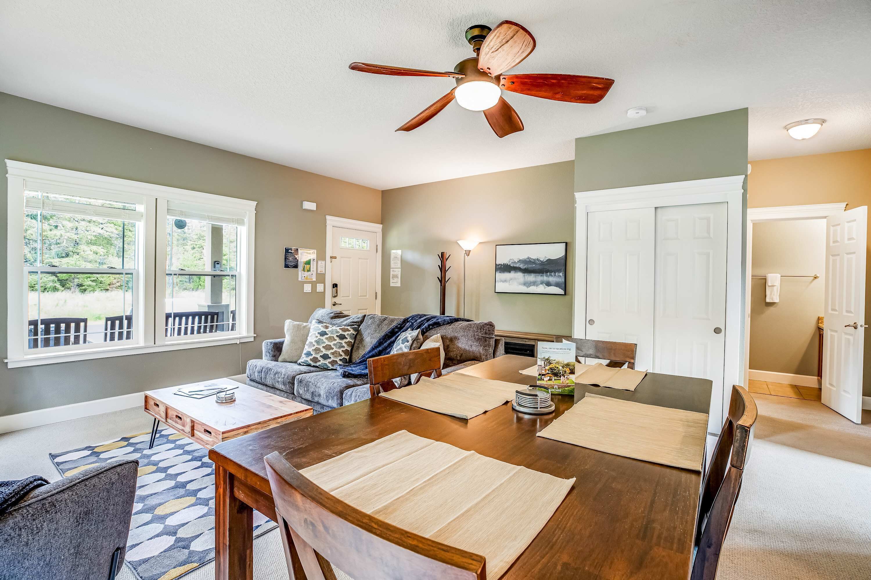A dining area with a wooden table, chairs, and a ceiling fan.