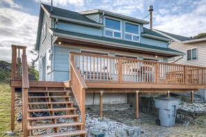 A two-story house with a wooden deck and a staircase leading to a balcony. - Dog friendly home across from the beach with grill deck and amazing ocean views (Rockaway Beach)