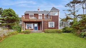A two-story house with a balcony, a front door, and a small porch area.
