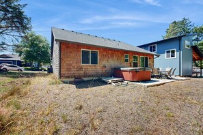 Une maison à deux étages avec une façade en briques, un jacuzzi et un espace patio.