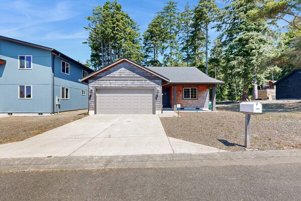 Une propriété résidentielle dotée d’un garage, d’une boîte aux lettres et d’une allée menant à la maison.