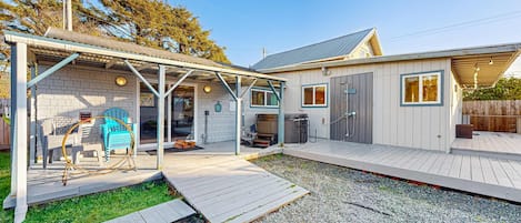 A house with a covered patio, a small deck, and a gravel driveway.