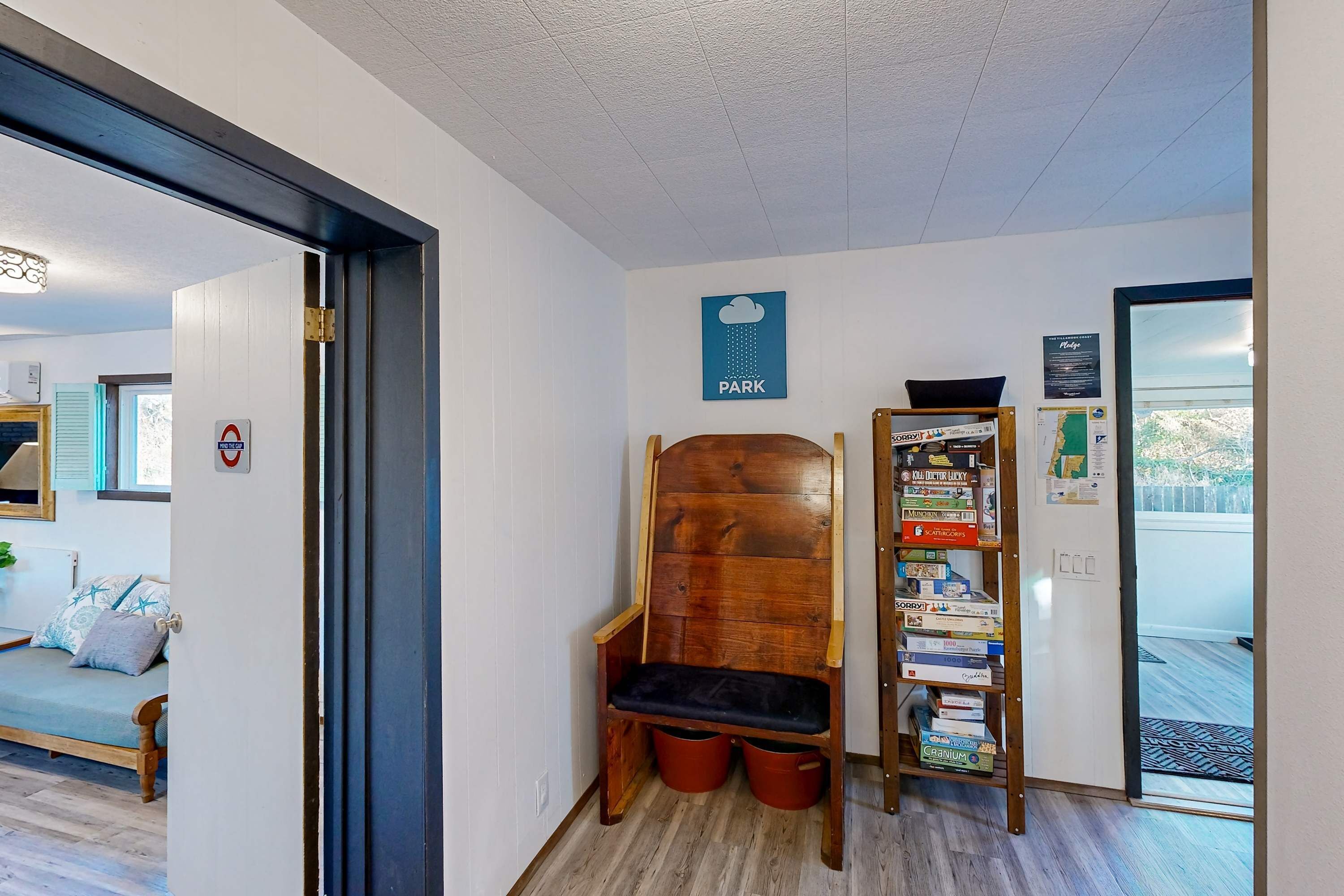 Un pasillo con un banco de madera, una estantería y una puerta que da a un balcón.