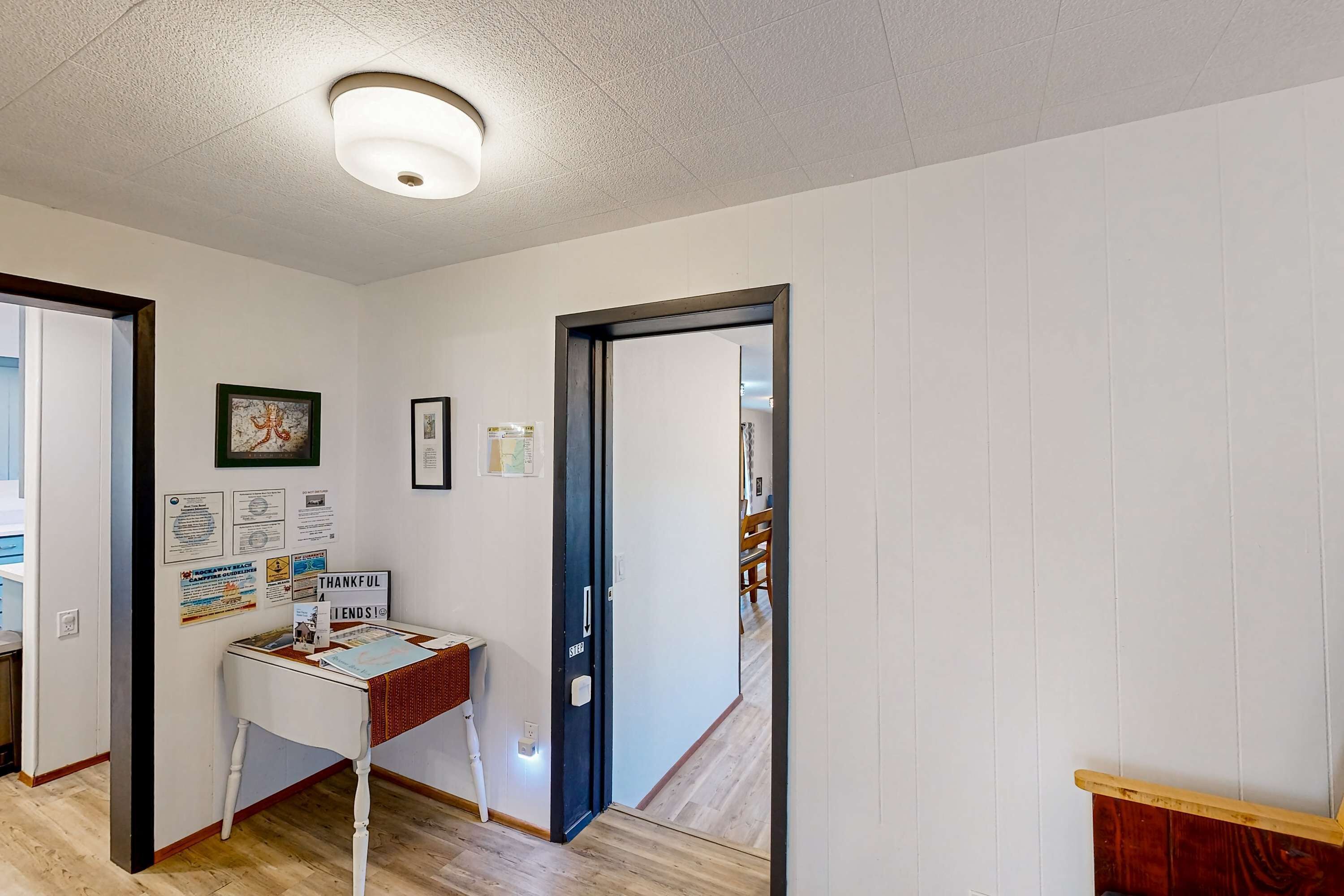 A hallway with a reception desk, framed certificates, and a door leading to another room.