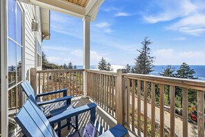 A wooden deck with a railing overlooking a coastal view.
