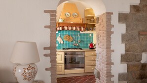 A kitchen with a brick wall, a stove, and a tiled backsplash. - Casa al Duomo by Wonderful Italy (Telti)